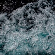 Deep blue ocean with surging white waves seen from above